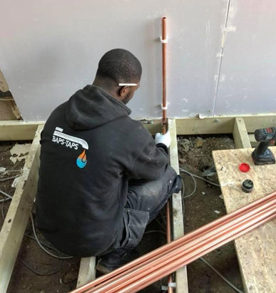 A plumber using a high-pressure hydro jet to clear a drain