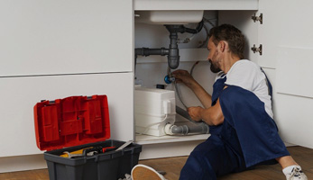 A plumber sealing a leaking water pipe